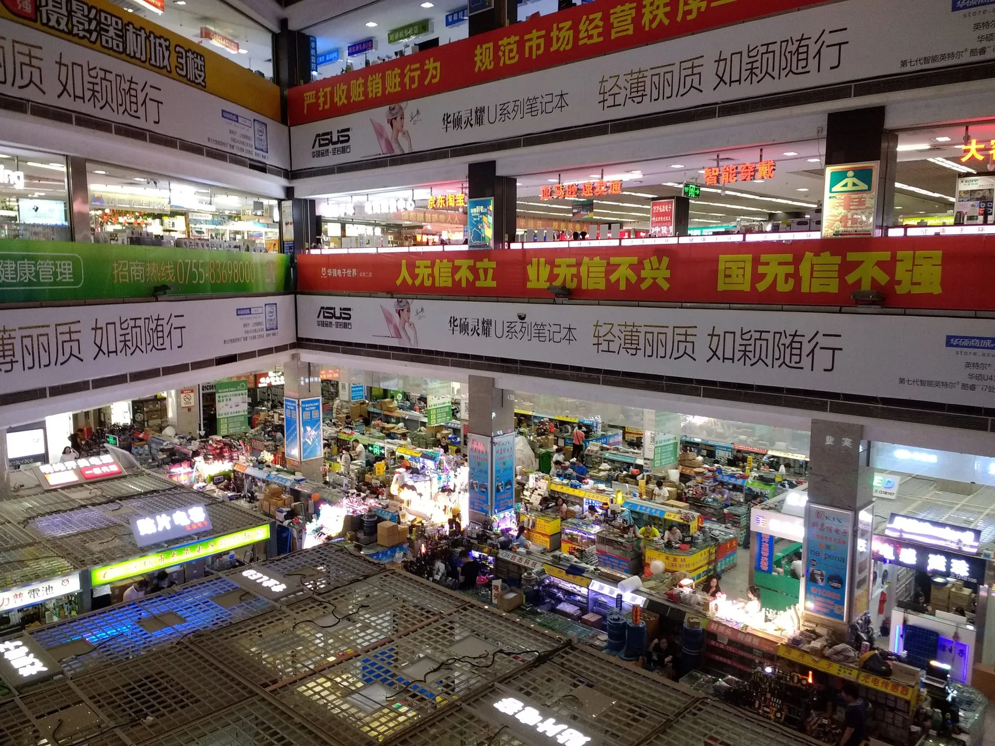 Trading floors inside the Huaqiangbei electronics market in Shenzhen, hung with shop signs